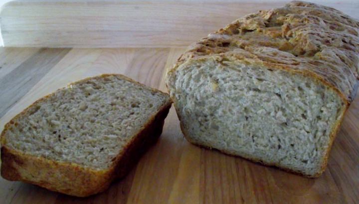 A loaf of rye bread with one slice exposed.