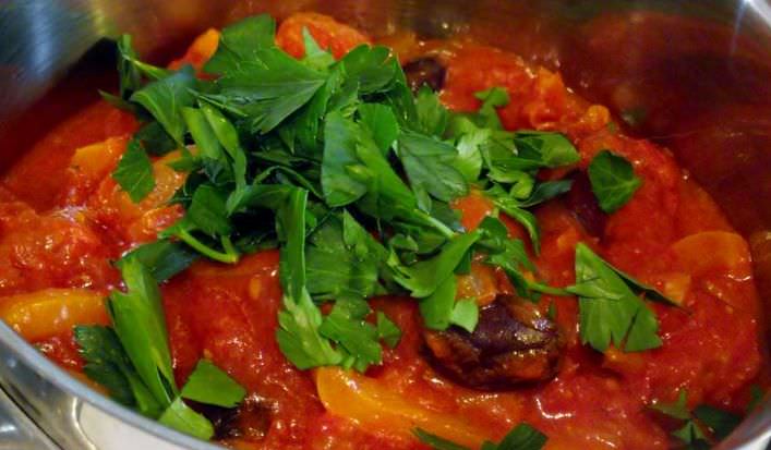 Parsley being added to the tomato sauce, at the end of cooking.