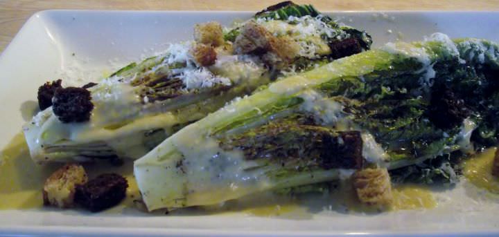 A grilled Caesar salad with croutons and shaved Parmigiano.