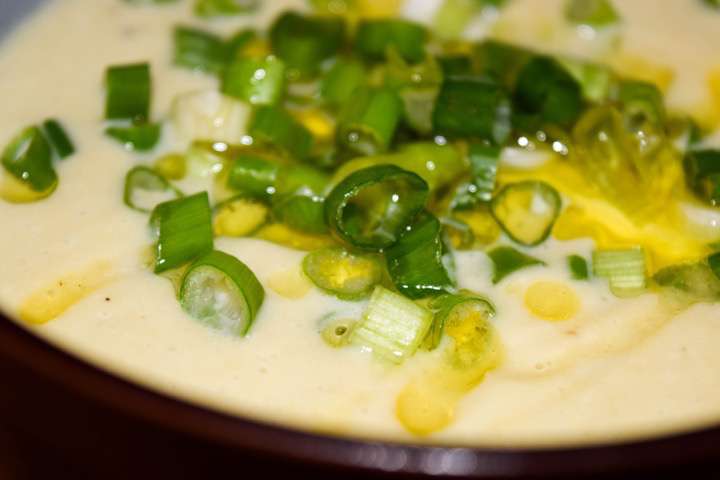 The finished soup garnished with scallions and extra virgin olive oil.