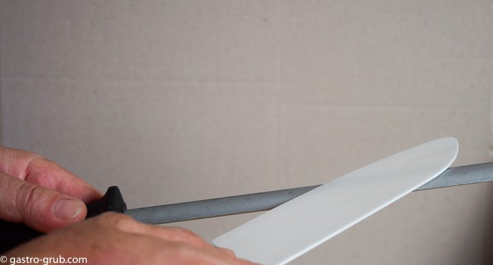 Sharpening a ceramic knife with a diamond steel.