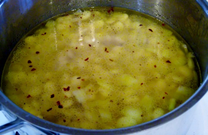 The lima beans in a pot going onto the stove.